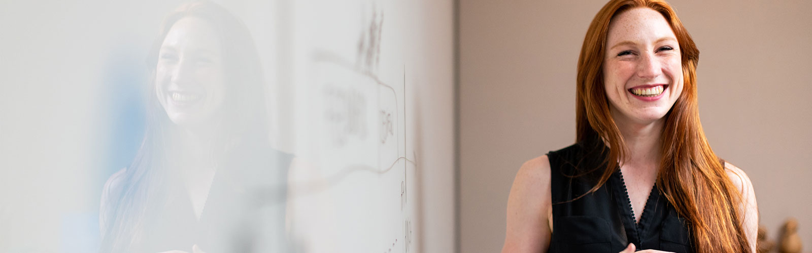 teacher in classroom in front of a white board